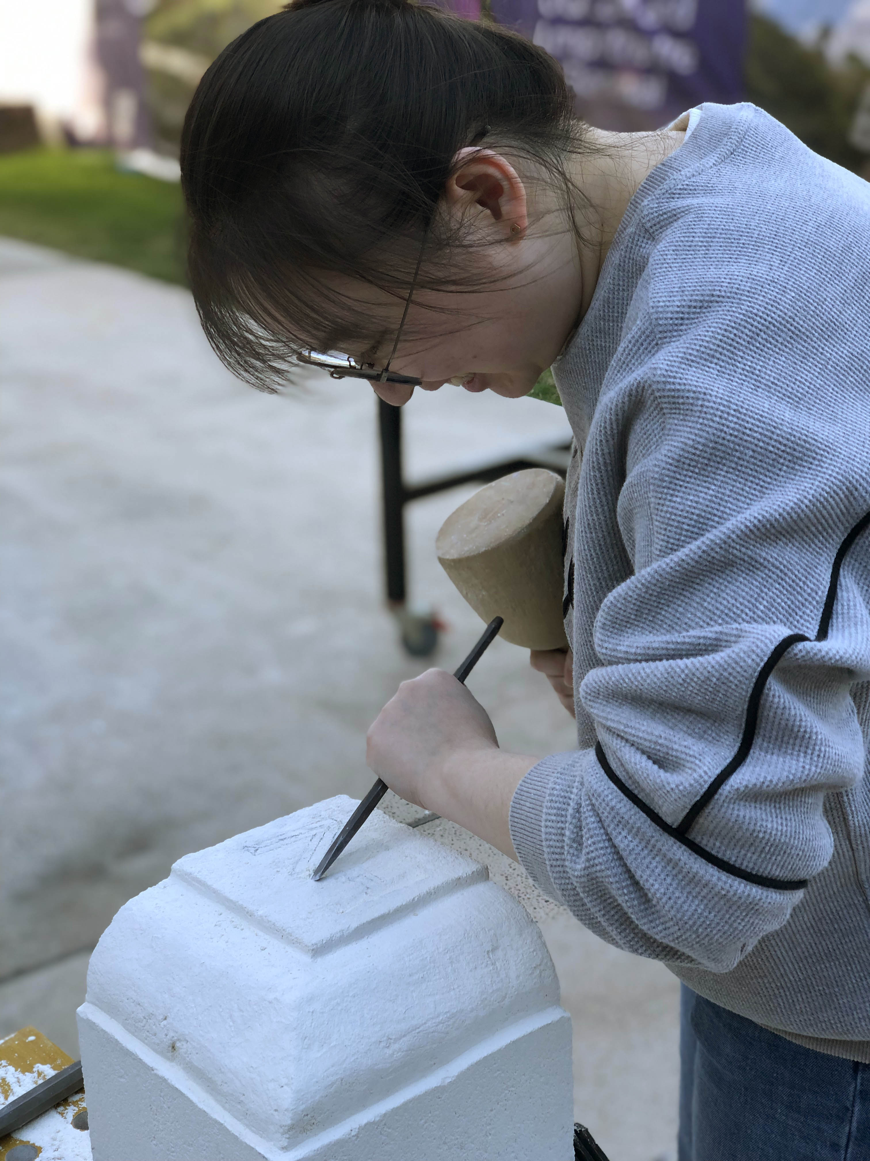 UQ student chisels her mason's mark into a limestone block
