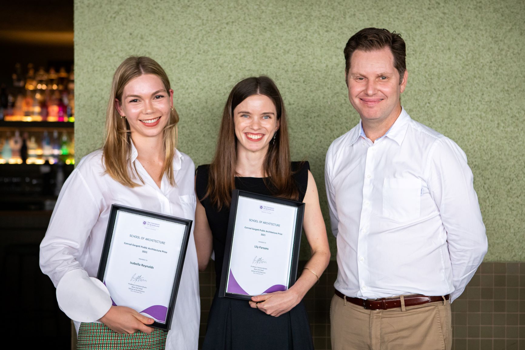 Graduands Isabella Reynolds and Lily Eire Parsons with Lawrence Toaldo, Conrad Gargett.